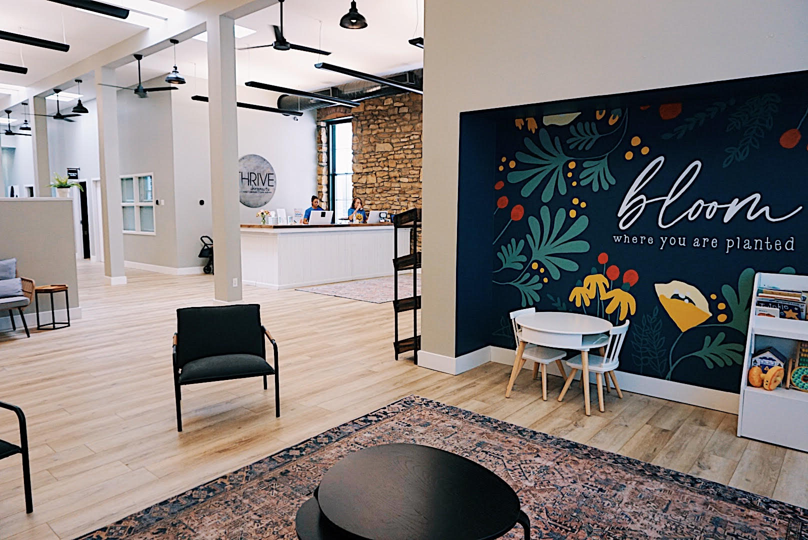 Modern Thrive Chiropractic office interior in Topeka featuring custom bloom mural and welcoming family-friendly atmosphere