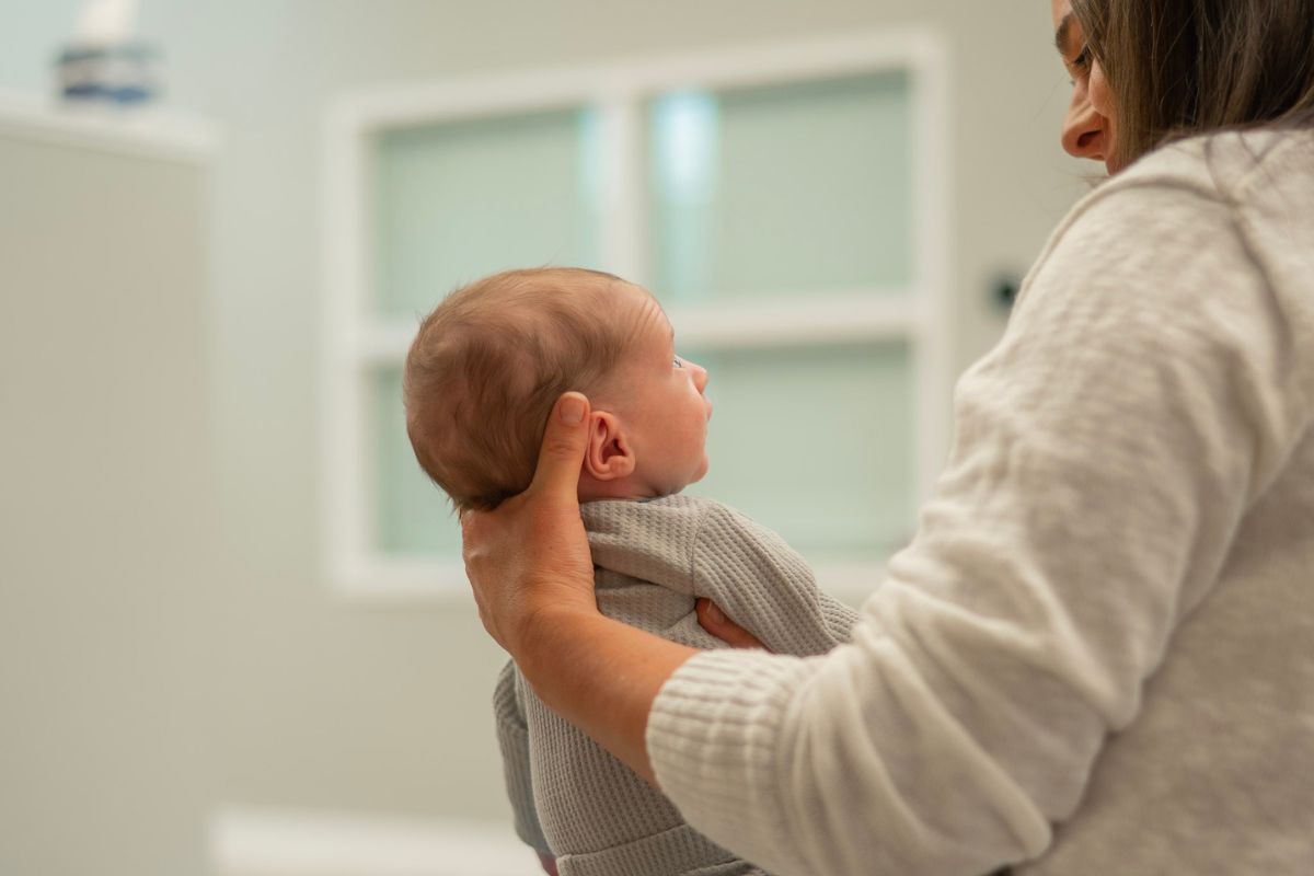 Mother holding newborn baby - women's health chiropractic from preconception through postpartum in Topeka Kansas