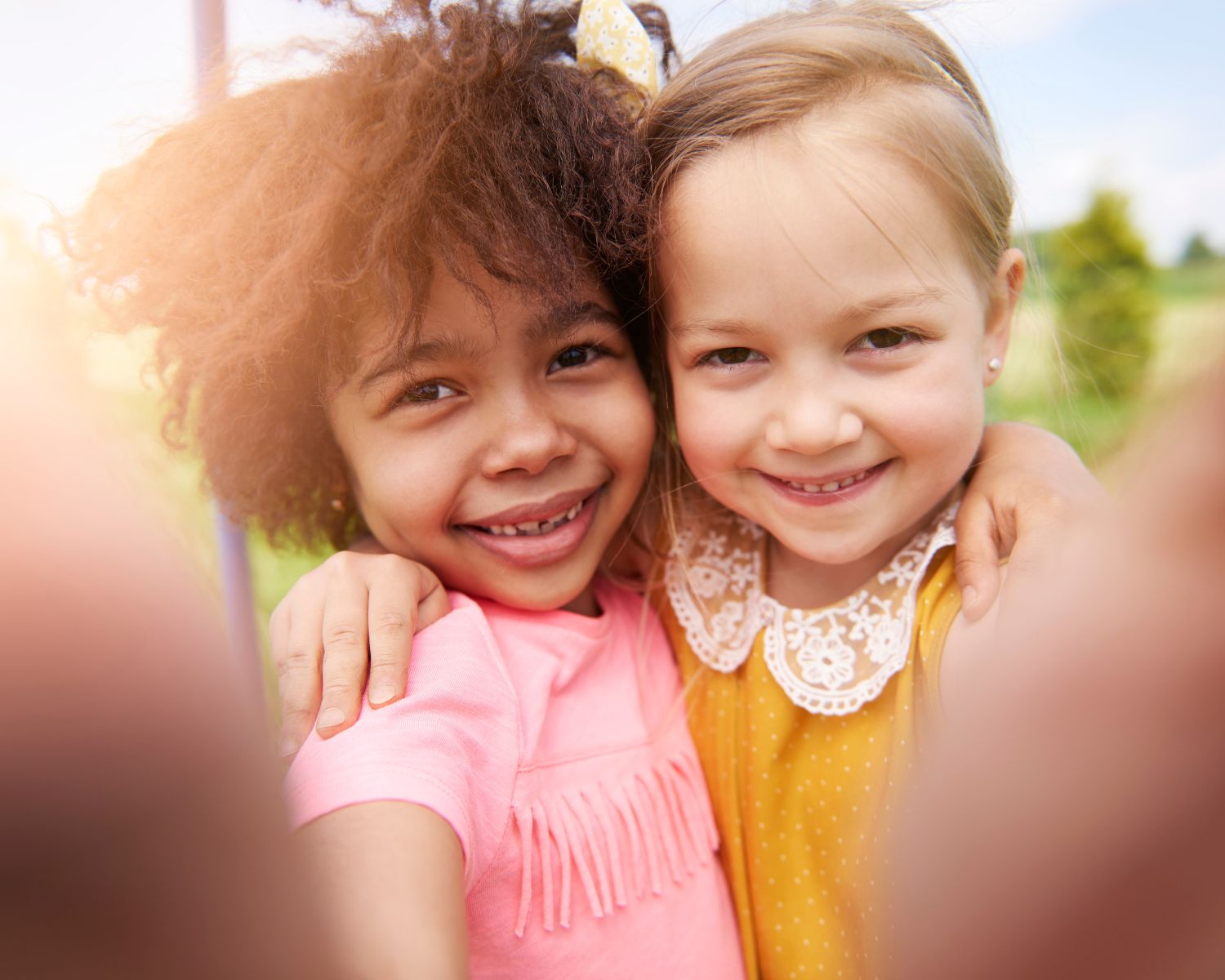Two happy young girls in Topeka enjoying outdoor play - pediatric chiropractic supports children's health and development